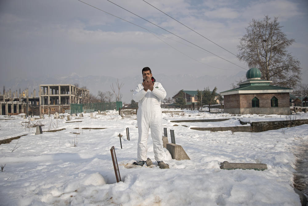 Jamil Ahmad Digoo, 47, an ambulance driver in Srinagar, Kashmir, prays in the Malkhah cemetery in Srinagar, where he has buried patients who died of COVID-19. Speaking of one of the women he buried, he says: 