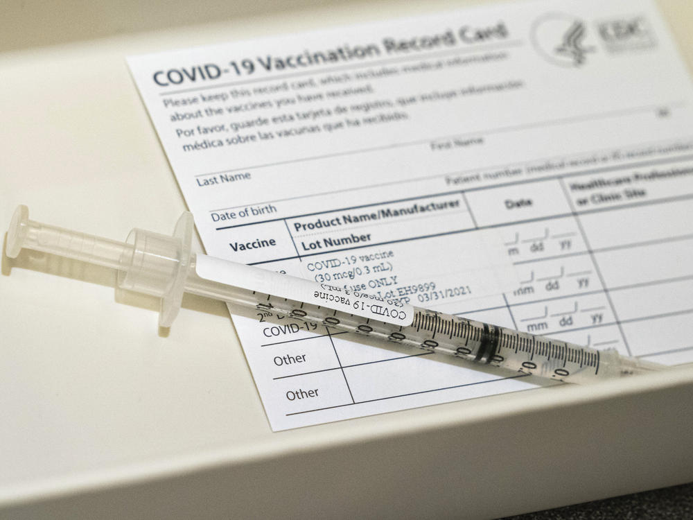 A syringe containing a dose of a Pfizer-BioNtech COVID-19 vaccine sits in a container, during a vaccine clinic at Providence Alaska Medical Center in Anchorage, Alaska. The state has become the first in the nation to offer the COVID-19 vaccine to any resident 16 or older.
