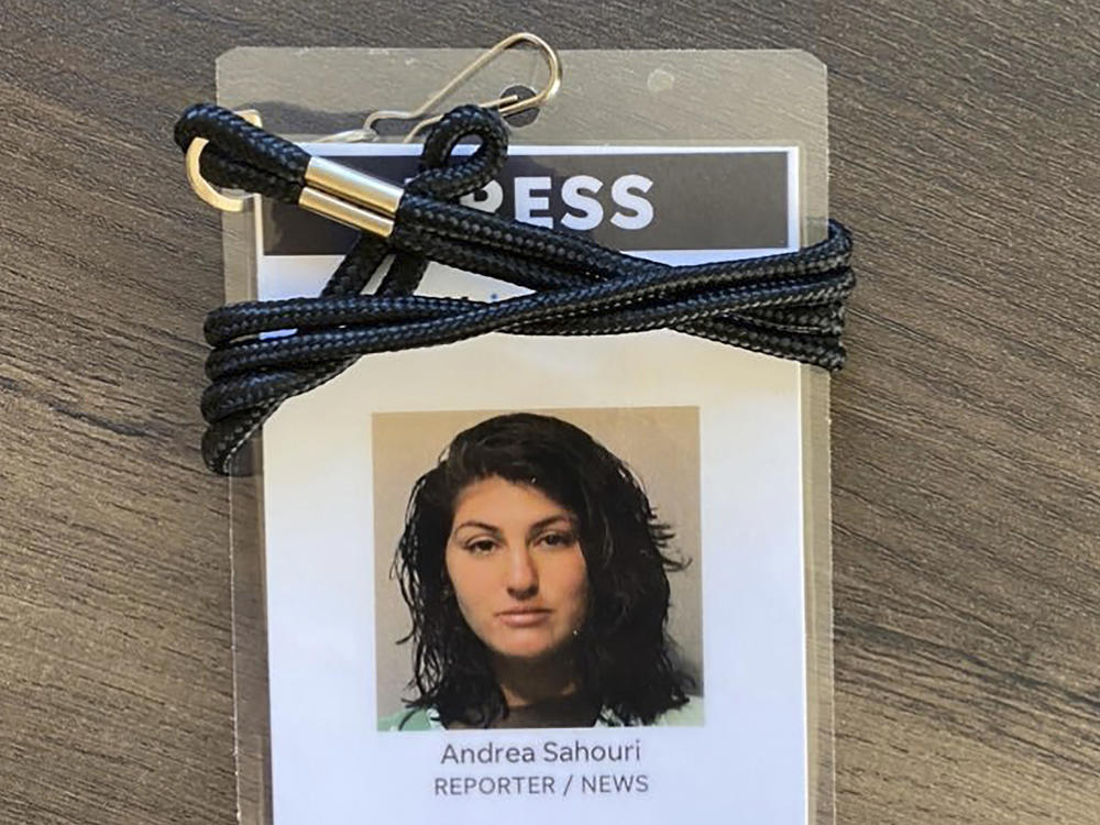 A press badge for <em>Des Moines Register</em> reporter Andrea Sahouri features the jail booking photo from her May 31 arrest while covering a Black Lives Matter protest.
