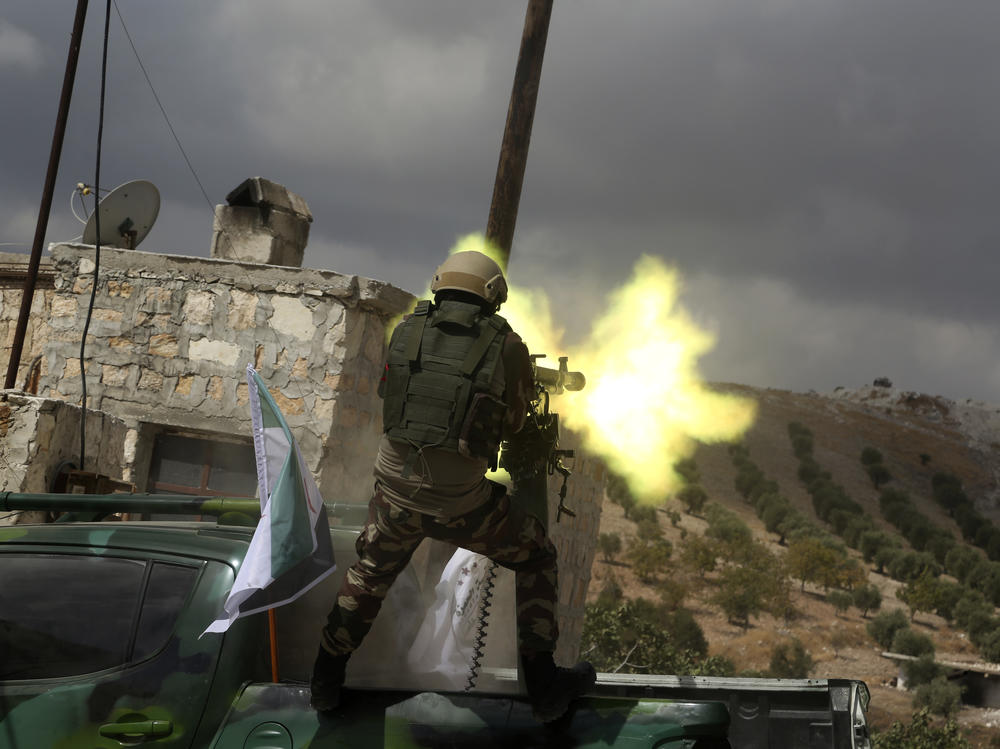 A fighter from Turkish-backed forces of the Free Syrian Army is shown in October 2019 firing a heavy machine gun during military training maneuvers in preparation for an anticipated Turkish incursion targeting Syrian Kurdish fighters, near Azaz, in north Syria.