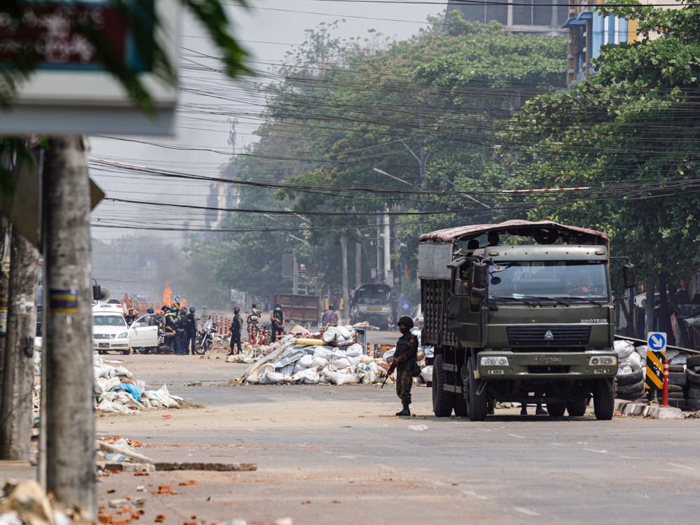Security forces stand guard on a road as people are arrested, next to dismantled barricades that were set up by protesters demonstrating against the military coup, in Yangon, Myanmar, on Friday.