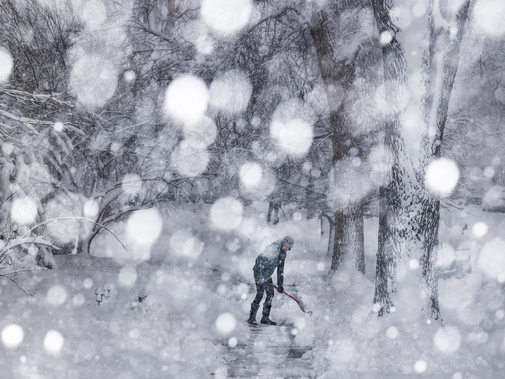 Kathy Gomez shovels her sidewalk on Sunday in Denver. Around 2,000 flights in and out of Denver have been canceled this weekend and highways around the state have been closed down as a winter storm pummels Colorado and neighboring states.