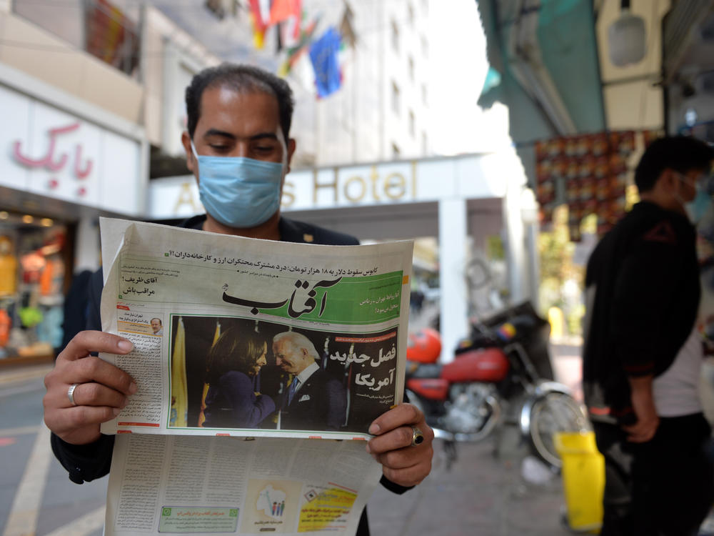 A man reads the news about the U.S. elections on Nov. 9 in Tehran. Many Iranians are hopeful that President Biden will lifts sanctions imposed on Iran by his predecessor.