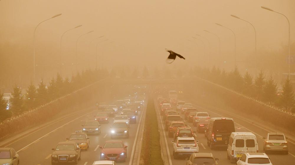 Motorists commute on a road during the sandstorm in Beijing, which also engulfed large parts of the country's north on Monday.