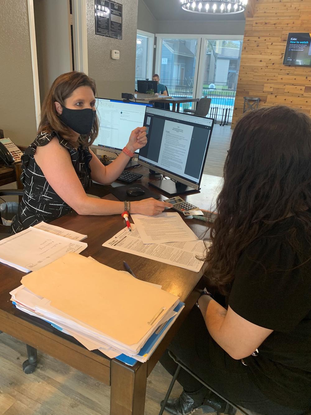 Stephanie Graves helps a tenant apply for rental assistance at the main office of one of her properties in Houston.