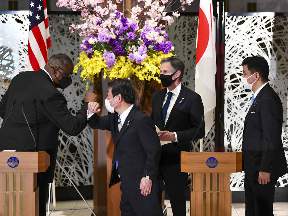 U.S. Defense Secretary Lloyd Austin, left, elbow bumps with Japan's Foreign Minister Toshimitsu Motegi, center, as Secretary of State Antony Blinken and Japanese Defense Minister Nobuo Kishi watch after a joint news conference in Tokyo Tuesday.