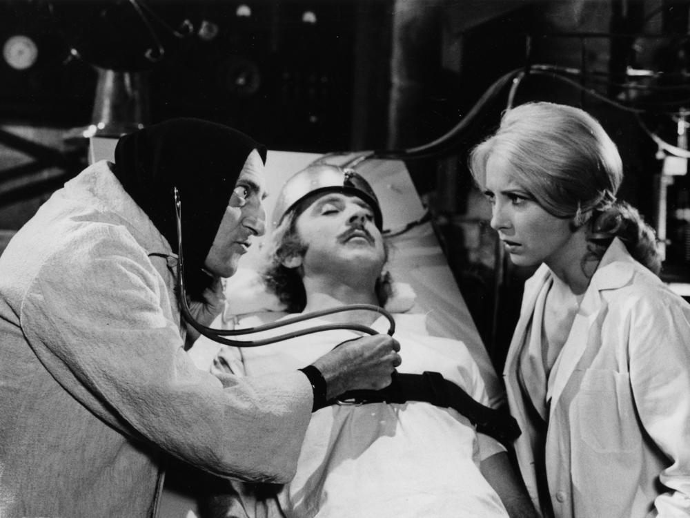 Marty Feldman listens to Gene Wilders' heart as Teri Garr looks on in a scene from the movie <em>Young Frankenstein</em>.