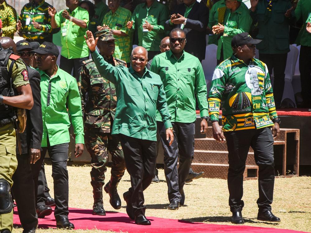 Tanzanian President John Magufuli (center) arrives to give a speech at a stadium in Dodoma, Tanzania, in August. Magufuli's death was announced Wednesday. He was 61.