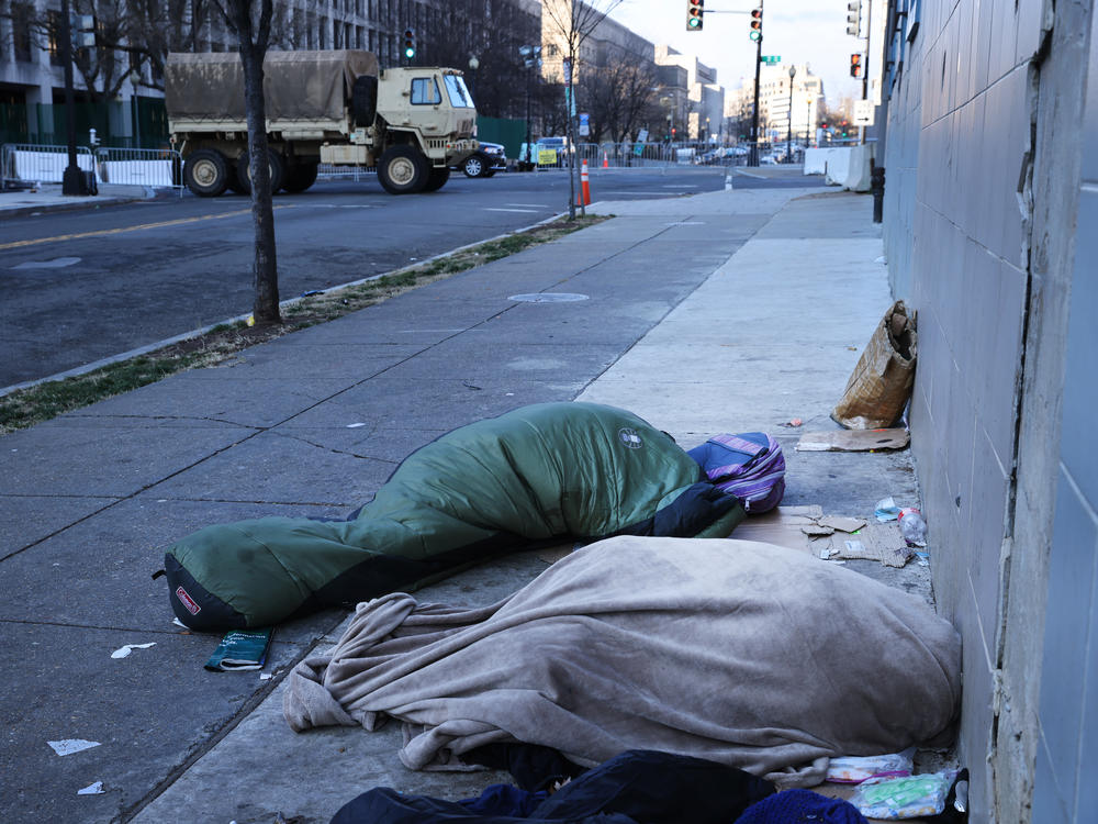 Homeless individuals sleep near a National Guard truck ahead of the inauguration of U.S. President-elect Joe Biden on Jan. 20, 2021, in Washington, D.C.