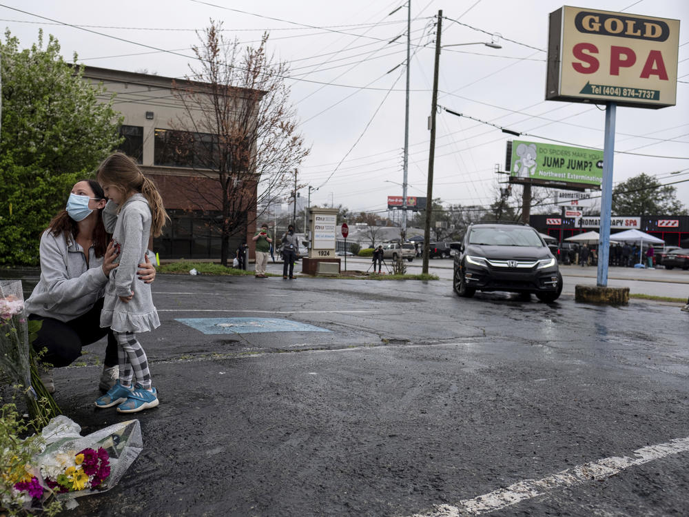 Mallory Rahman and her daughter Zara Rahman, 4, bring flowers to the Gold Spa in Atlanta on Wednesday, the day after eight people were killed at three massage spas in the Atlanta area. Authorities have arrested Robert Aaron Long, 21, in the shootings in Atlanta and Cherokee County, Ga.