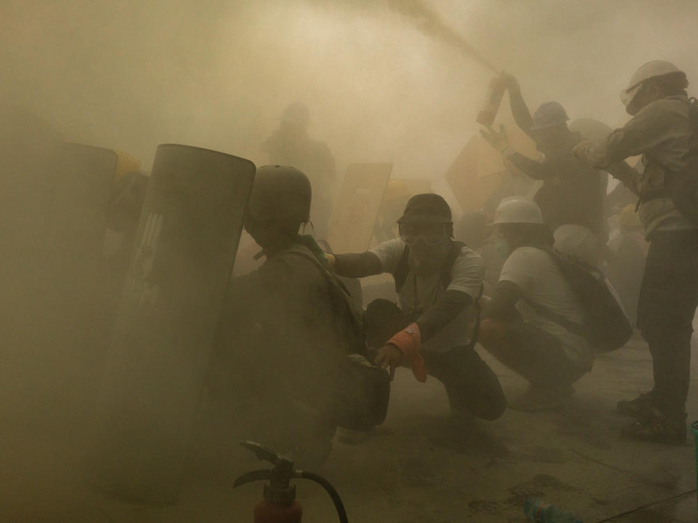 Protesters defend themselves with makeshift shields during clashes with riot police as the military government intensified its crackdown on demonstrations, on Feb. 28, in Yangon, Myanmar.