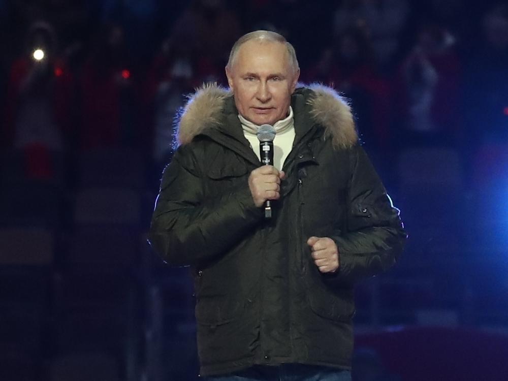 Russian President Vladimir Putin speaks Thursday before a concert marking the seventh anniversary of the annexation of Crimea from Ukraine. The banner behind him reads, 