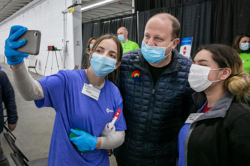 Gov. Jared Polis poses for a selfie with health staffers at a mass vaccination clinic at the National Western Center in Denver on Feb. 6.