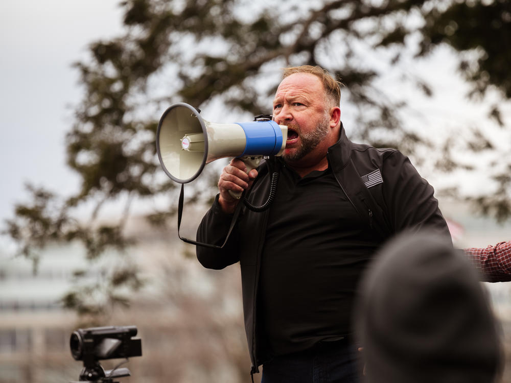 Alex Jones addresses a pro-Trump crowd on Jan. 6, the day of the U.S. Capitol riot. Jones is widely known for his support of baseless and often bigoted conspiracy theories, and he has been banned from many tech platforms, though not Amazon.