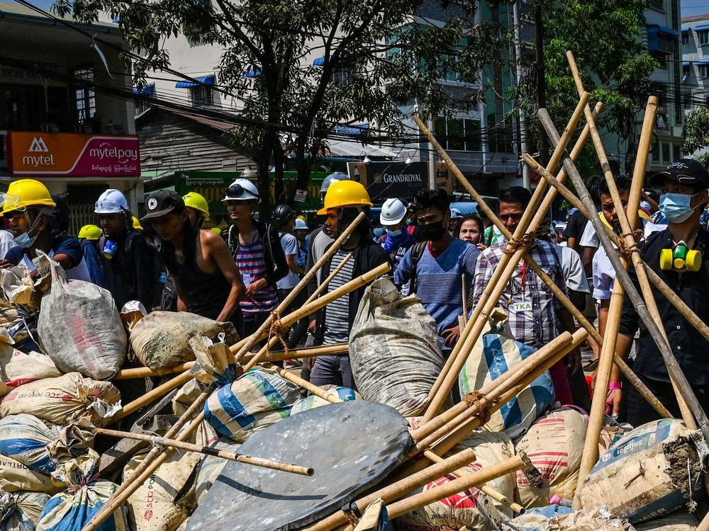 Protesters take cover behind makeshift barricades during a demonstration against the military coup in Yangon's Thaketa township on Friday.