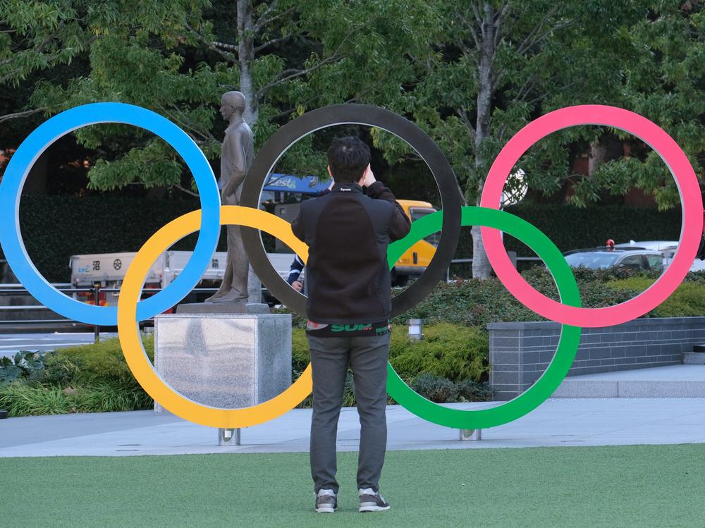 A couple takes pictures with the Olympic rings monument near the National Stadium for the Tokyo 2020 Olympic Games on Feb. 4. Organizers have decided that overseas spectators won't be allowed to attend the Games this summer.