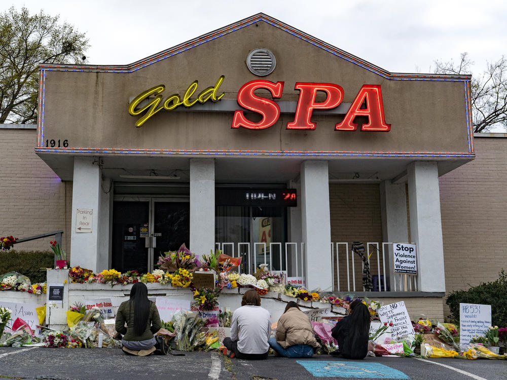 Mourners during a quiet moment at Gold Spa, where dozens have left bouquets and candles in the days since Tuesday's shootings.