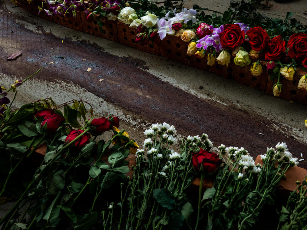 Flowers line the street next to dried blood at the spot where Chit Min Thu, 25, was killed in clashes on March 11 in Yangon, Myanmar. The military junta cracked down brutally on a nationwide civil disobedience movement in which thousands of people have turned out in defiance of tear gas, rubber bullets and live ammunition.