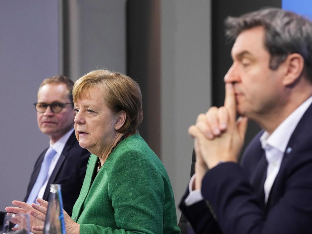 German Chancellor Angela Merkel, with Bavaria's State Premier Markus Soeder (right) and Berlin's Mayor Michael Mueller, participate in a news conference following talks via videoconference with Germany's state premiers on the extension of the current COVID-19 lockdown in Germany.