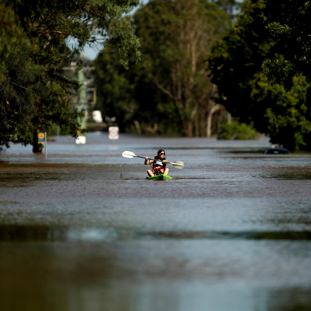 A local resident paddles along a flooded street in the Sydney suburb of McGraths Hill on Wednesday.