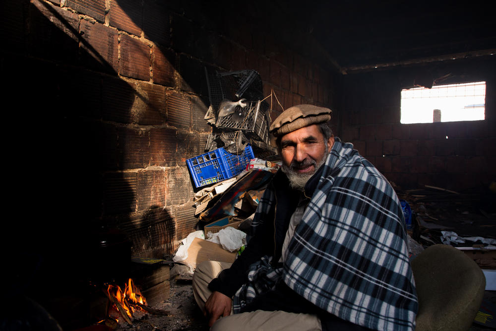 Mangal Saifullah, 57, from Afghanistan prepares his lunch, boiling some water on an improvised fire near his shelter in the former Krajina Metal factory. He has been in Bosnia for a year.