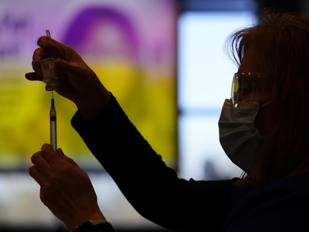 A county health worker fills a syringe with the Moderna COVID-19 vaccine in West Chester, Pa., in late December. Rutgers University will require students enrolling for the fall semester to show they have received a COVID-19 vaccine.
