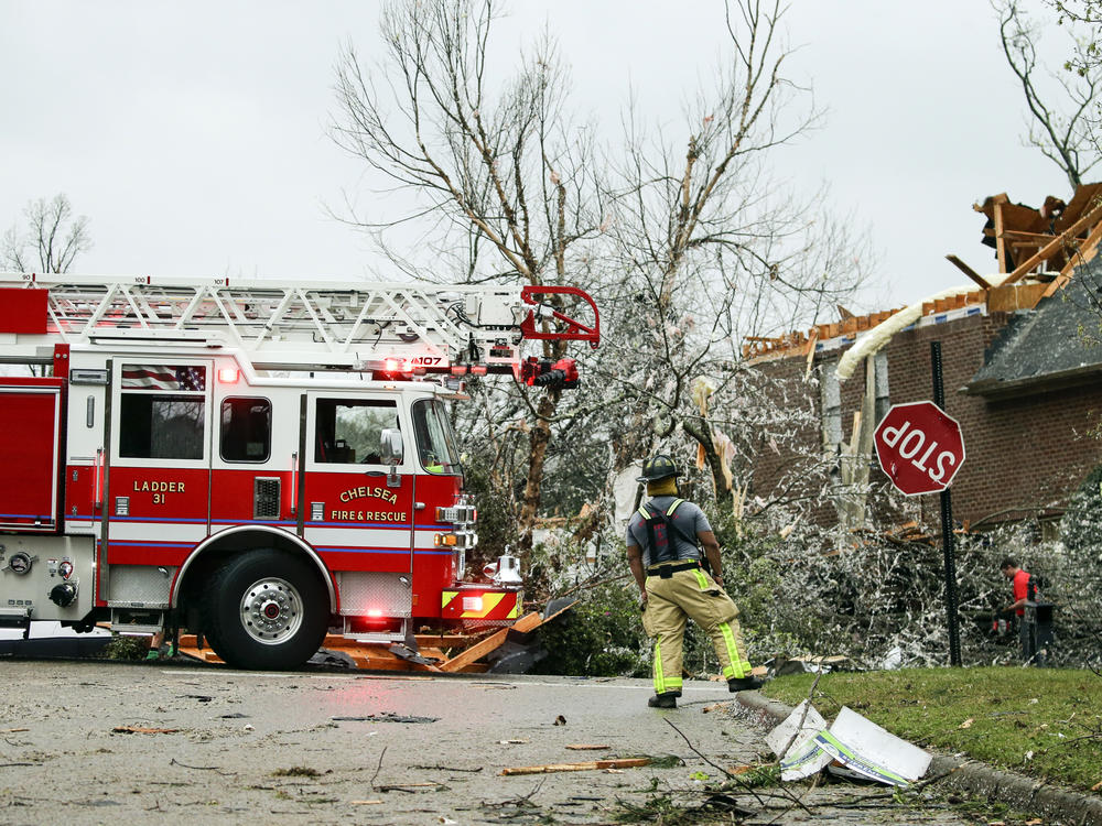 A firefighter surveys damage after a tornado touches down south of Birmingham, Ala., in the Eagle Point community damaging multiple homes.
