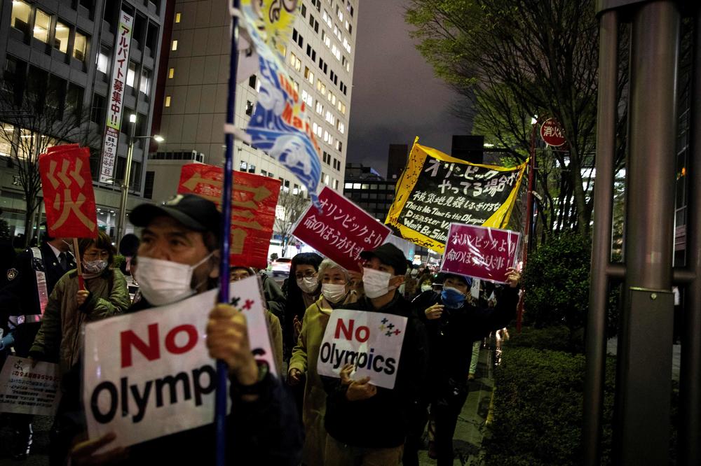 People demonstrate as they hold slogans against the Tokyo 2020 Olympic Games planned for this summer, during a protest in Tokyo on Thursday, the first day of the Olympic torch relay.