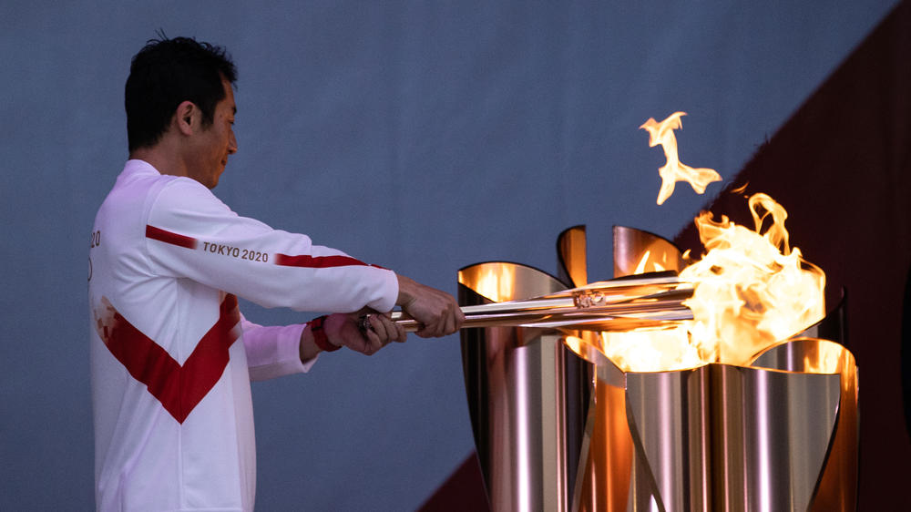 Aerobatics pilot Yoshihide Muroya lights the cauldron during the Tokyo Olympic Games torch relay on Thursday in Minamisoma, Fukushima, Japan.
