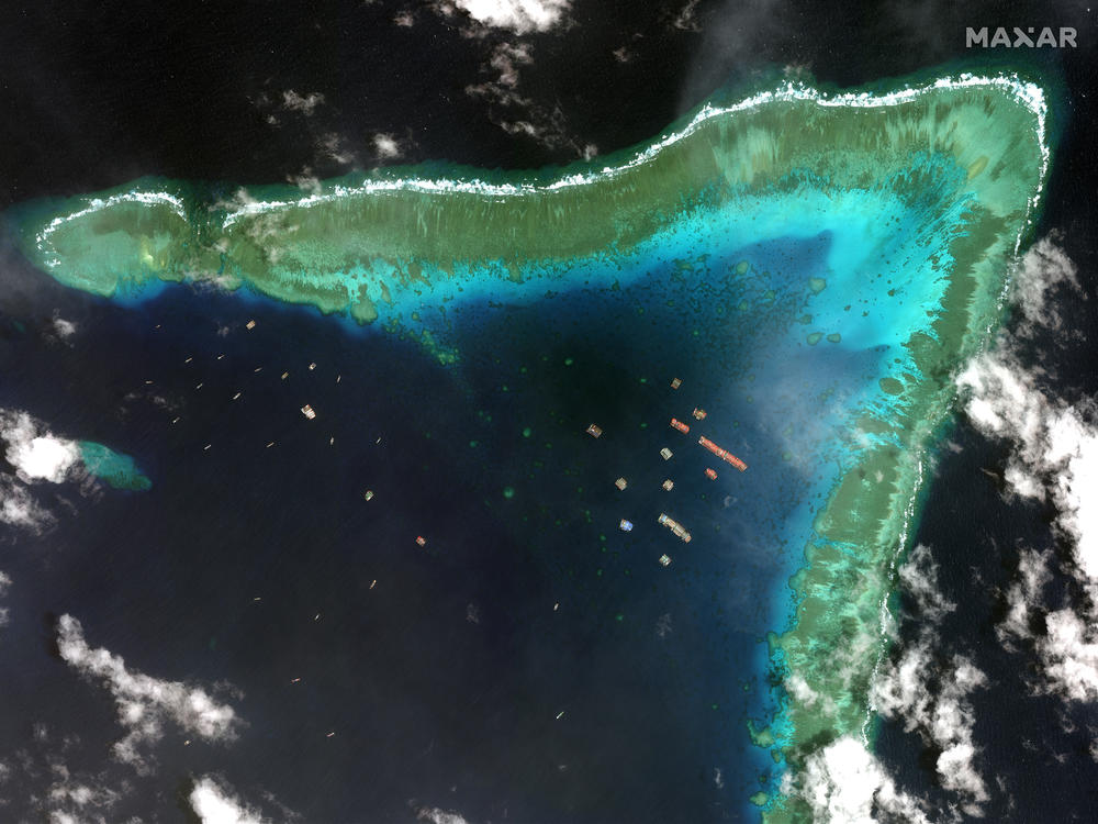 Overview of Whitsun Reef in the South China Sea and Chinese vessels moored in the waters surrounding the boomerang-shaped coral reef on March 23.
