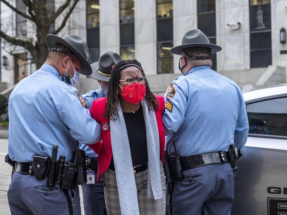 State Rep. Park Cannon is placed into the back of a Georgia State Capitol patrol car after being arrested at the state Capitol. Cannon was arrested after she attempted to knock on the door of Gov. Brian Kemp's office during his remarks after signing into law a sweeping Republican-sponsored overhaul of state elections.