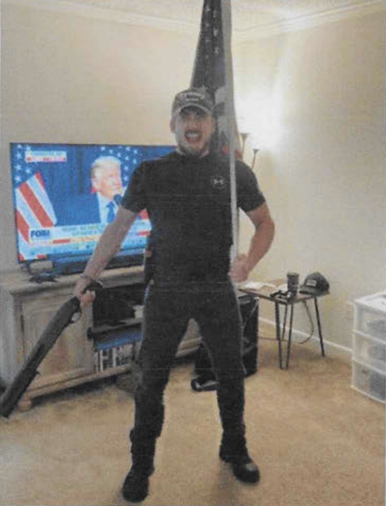 Dominion's lawsuit against Fox News says that some of the channel's viewers, including Eric Gavelek Munchel, believed its claims of voter fraud with such fervor they rampaged at the U.S. Capitol. Here, Munchel poses in front of a TV showing the Fox Business Channel.