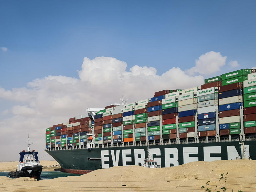 A tugboat participates in an attempt on Friday to refloat the Ever Given, a container ship that has been stuck in the Suez Canal since it ran aground on Tuesday.