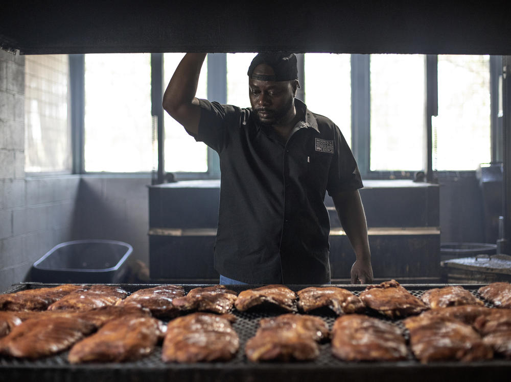 Rodney Scott checks racks of ribs as they cook on July 3, 2018 in Charleston, S.C.