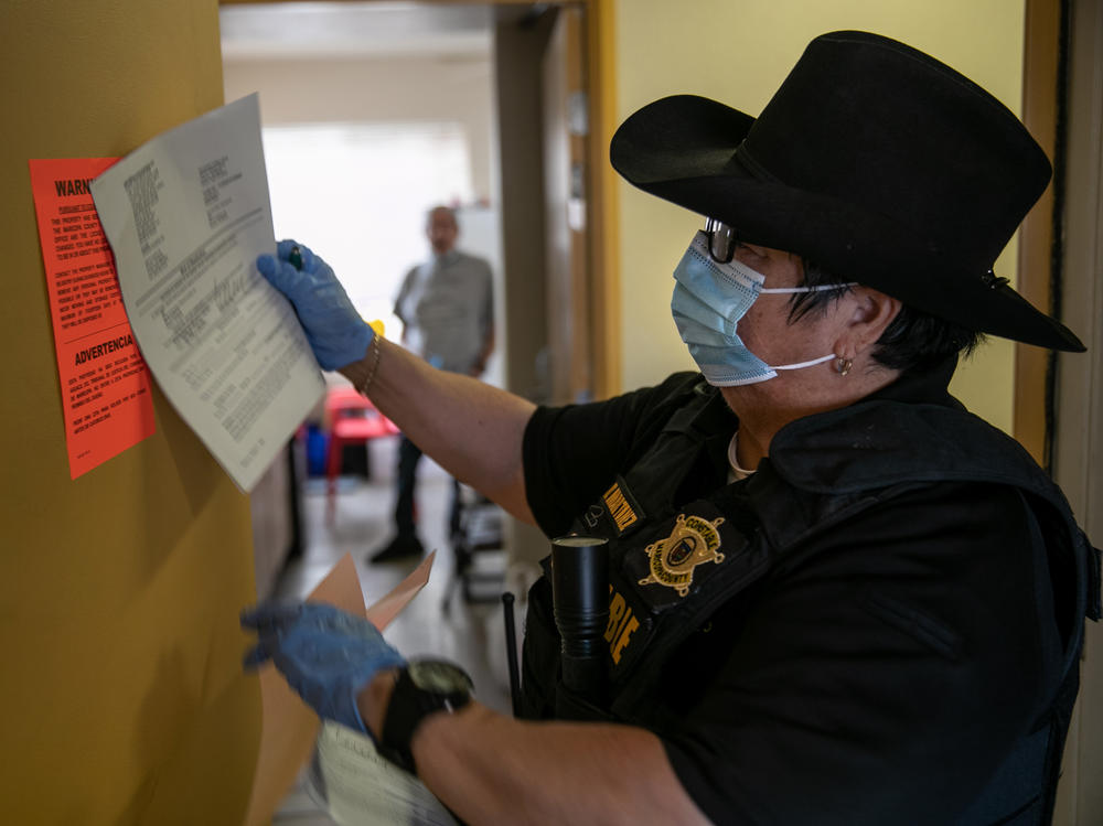 A constable posts an eviction order for nonpayment of rent in October in Phoenix. The CDC is extending an order aimed at preventing evictions.