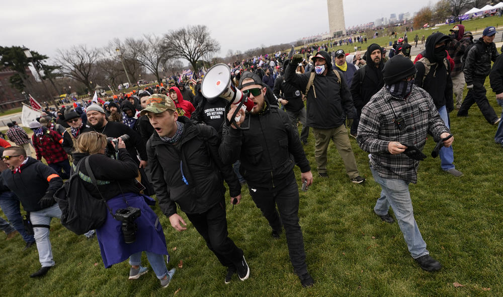 Ethan Nordean, with backward baseball hat and bullhorn, leads members of the far-right group Proud Boys in marching before the riot at the U.S. Capitol on Jan. 6.