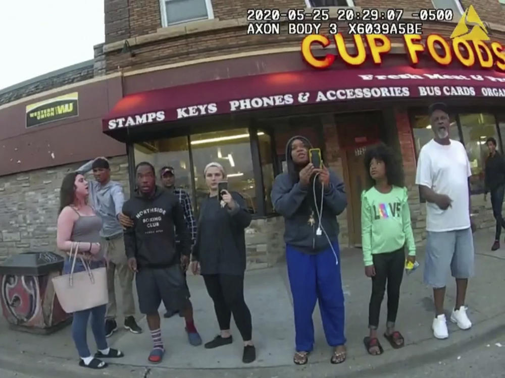 This image from a police body camera shows people gathering as former Minneapolis police officer Derek Chauvin was recorded pressing his knee on George Floyd's neck for several minutes as onlookers yelled at Chauvin to get off and Floyd said that he couldn't breathe on May 25, 2020 in Minneapolis.