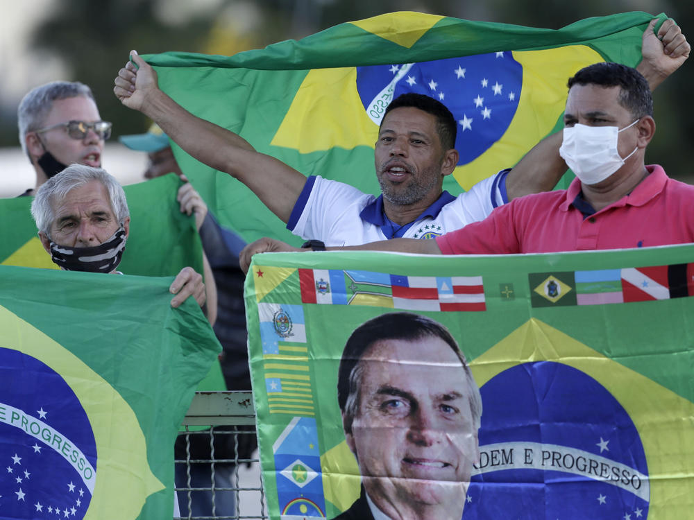 Demonstrators show support for Brazilian President Jair Bolsonaro in front of the presidential palace Monday in Brasilia. Bolsonaro reshuffled his Cabinet amid turmoil in his administration and dropping approval ratings over the coronavirus pandemic.