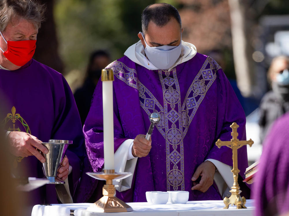 The Rev. Michael Amabisco blesses ashes during an Ash Wednesday service at St. Raymond Catholic Church in Menlo Park, Calif., in February. A new Gallup survey finds that those professing church membership has fallen 18 percentage points among Catholics since 2000.