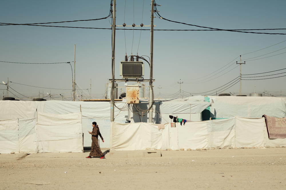 A Yazidi woman walks through the Khanke camp in northern Iraq in February.