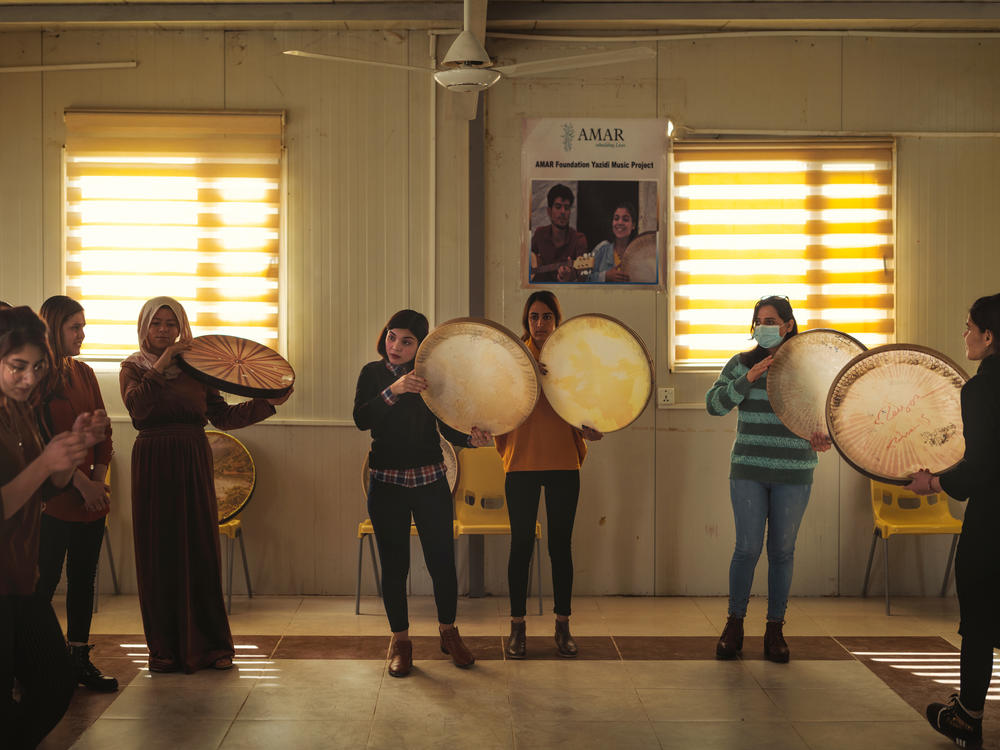 Rana Sulaiman Halo (center), performs with a traditional <em>daf</em> drum with the Ashti (Peace) Choir.