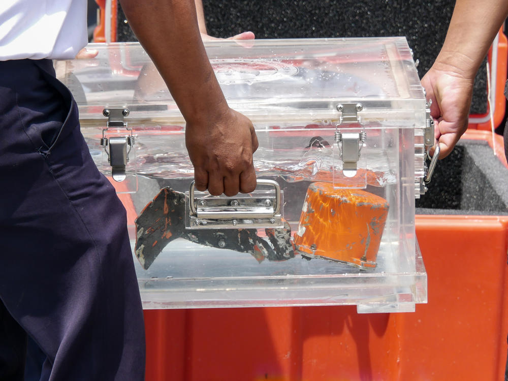 Indonesia's National Transportation Safety Committee (KNKT) officers carry the memory unit from a cockpit voice recorder recovered from the crashed Sriwijaya Air Flight SJ 182 at Tanjung Priok Port in Jakarta on Wednesday.