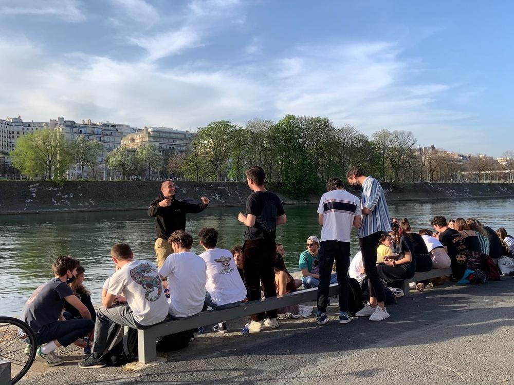 Young people gathered Wednesday by the Seine River in Paris, largely without masks and without social distancing. French President Emmanuel Macron has ordered the country into a third lockdown because of the continued spread of COVID-19.