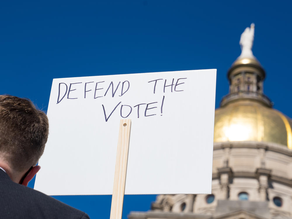 Demonstrators protest House Bill 531 last month in Atlanta. The legislation signed into law has drawn criticism from voting rights activists and businesses, who say it limits access to the polls and disproportionately harms voters of color.