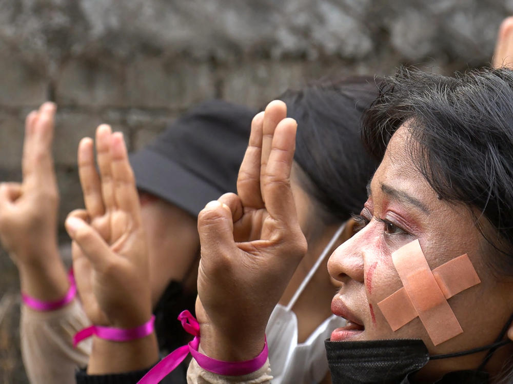 Protesters, wearing red makeup to simulate tears of blood, making the three-finger salute during a demonstration against the military coup in Hlaing Township, Yangon, Myanmar, on Thursday in a photo taken from a screenshot from AFPTV video.
