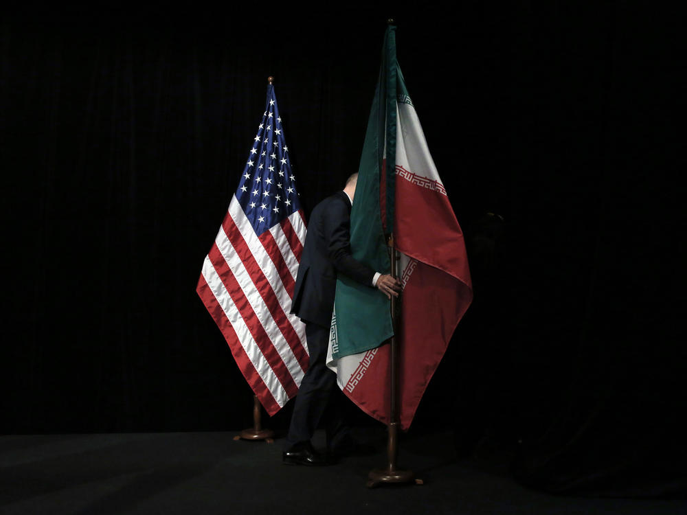 A staff person removes the Iranian flag from the stage after a group picture with representatives of the United States, Iran, China, Russia, Britain, Germany, France and the European Union during the Iran nuclear talks in July 2015 in Vienna.