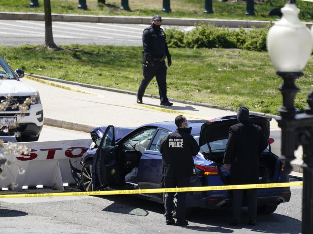 Capitol Police officers stand near a car that crashed into a barrier Friday on Capitol Hill.