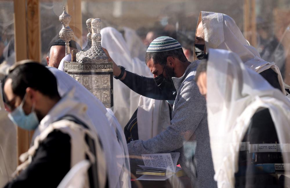 Jewish worshippers hold a Torah scroll as they recite the Priestly Blessing on the holiday of Passover in front of the Western Wall in Jerusalem on Monday.