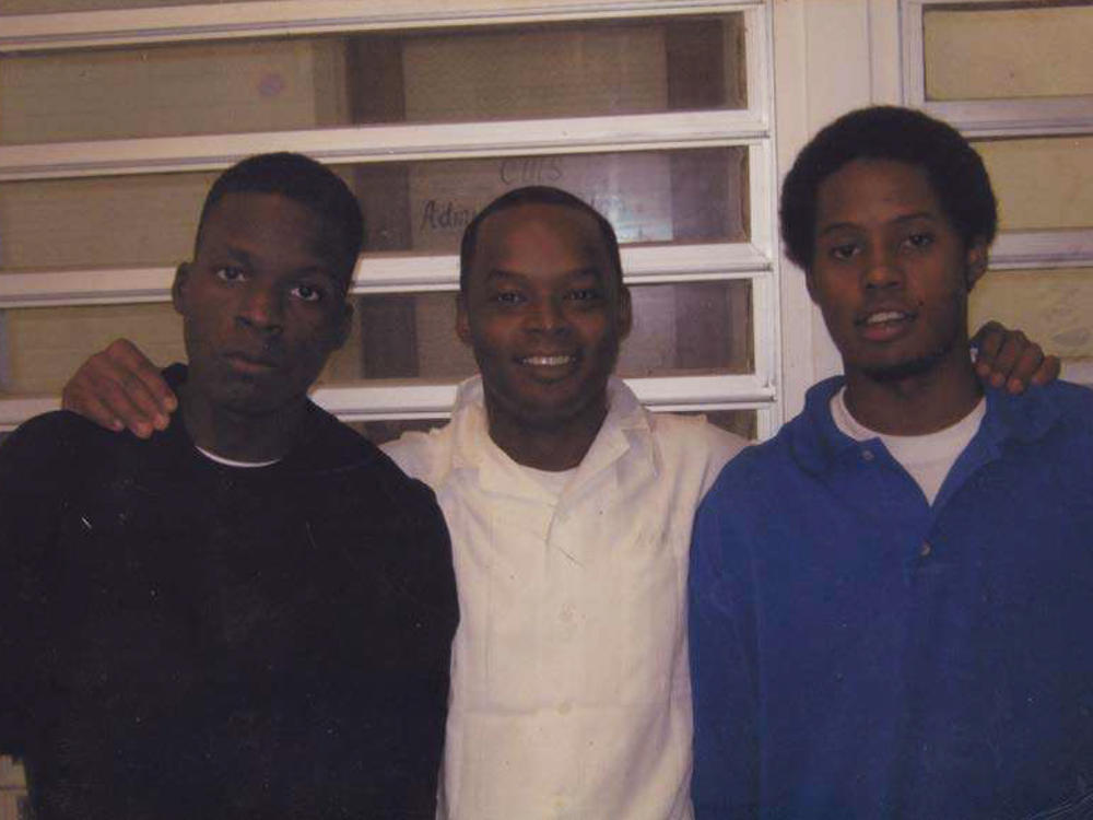 Toforest Johnson (center) with two of his five children.