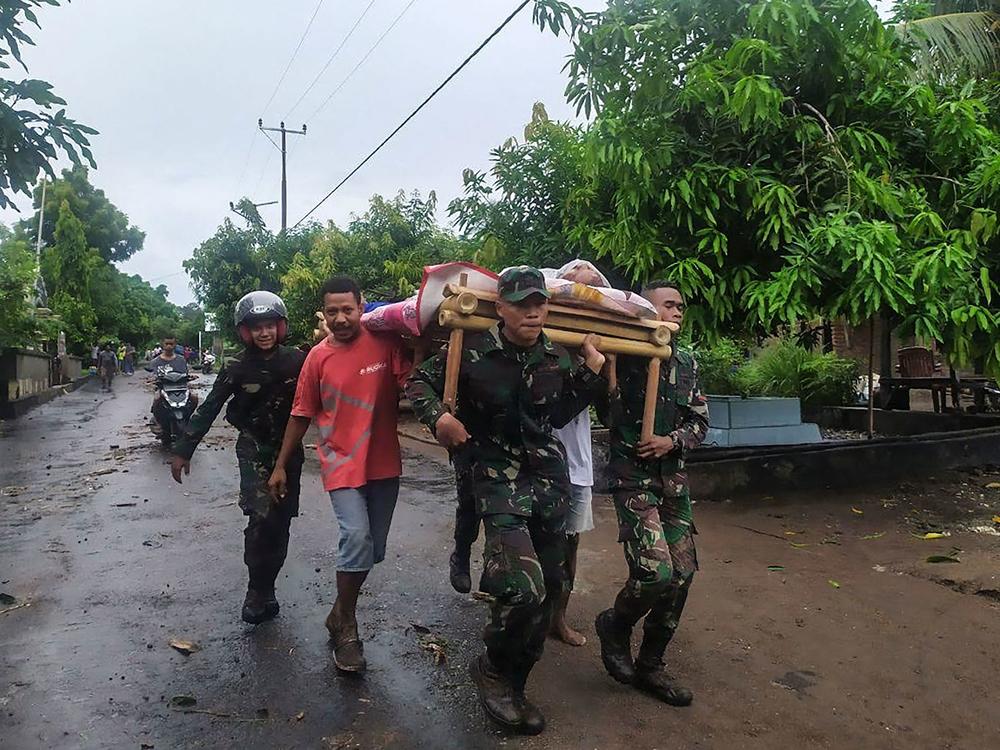 Villagers carry a body Monday after flash floods in Lembata, East Flores, Indonesia, as torrential rains triggered floods and landslides that have killed dozens of people in the region.